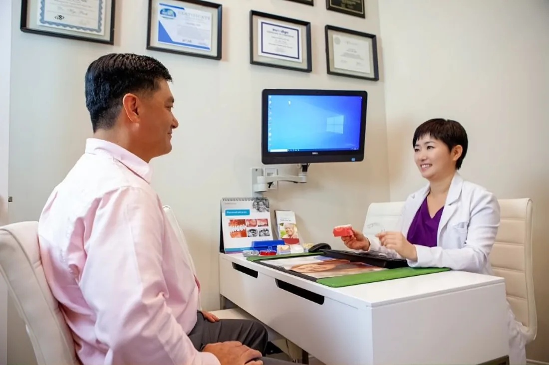 Dr. Hye Park listening to a patient at Green Dentistry in Alexandria, VA